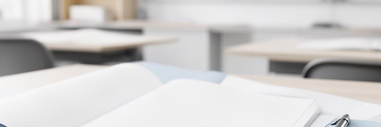 Geöffnete Kursunterlagen mit Stift auf einem hellen Tisch in einem Sprachkursraum